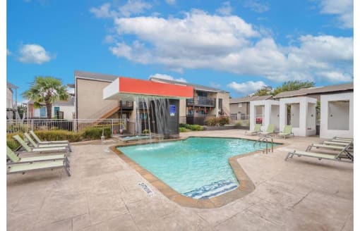 a swimming pool with chairs and a building in the background at Cityscape, Dallas, TX