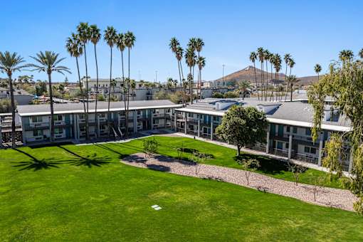 A large building with a green lawn in front of it at Presidio Palms Apartments, Tucson