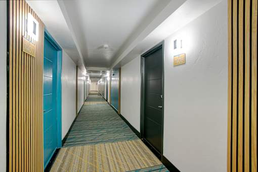 A long hallway with doors on both sides and a striped wall on the right at Presidio Palms Apartments, Arizona, 85701