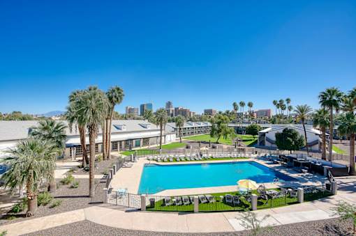 A pool surrounded by palm trees at Presidio Palms Apartments, Tucson, AZ