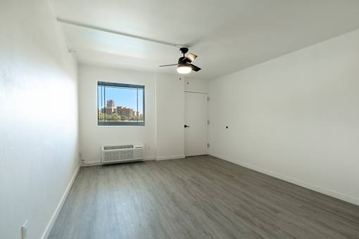 Spacious room with a ceiling fan and a window at Presidio Palms Apartments, Tucson, AZ