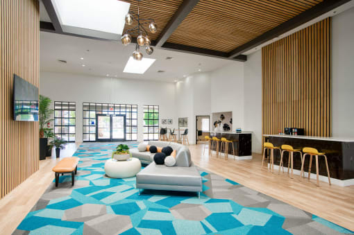 the clubhouse of an apartment building with a blue rug and furniture at Presidio Palms Apartments, Arizona, 85701