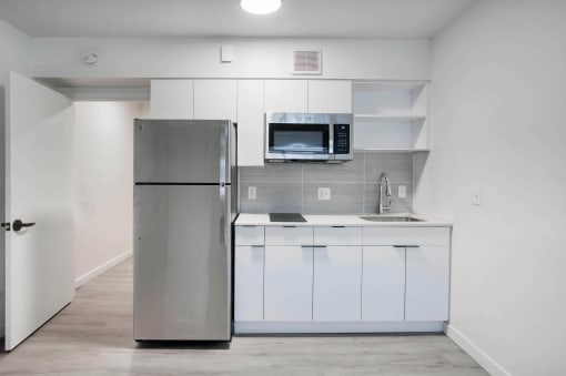 a kitchen with refrigerator and white cabinets at Presidio Palms Apartments, Tucson, AZ