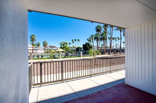 A balcony with a metal railing and a view of palm treesat Presidio Palms Apartments, Tucson, 85701