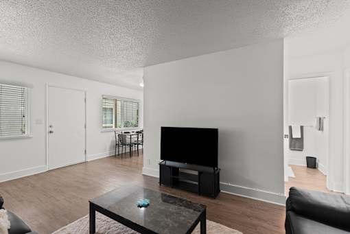 A living room with a black coffee table and a black television.