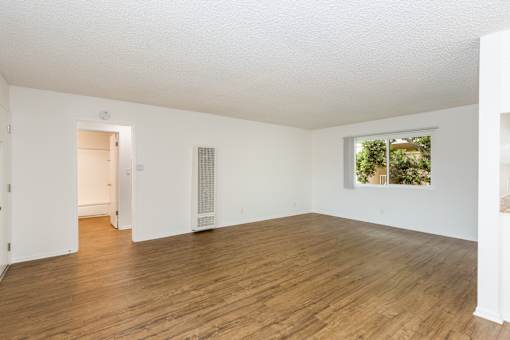 A living room with wooden floors and white walls.