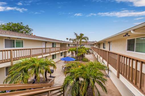 A sunny day at the apartment complex with a blue umbrella in the courtyard.