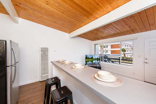 A kitchen with a refrigerator, a counter, and a window at The Wave