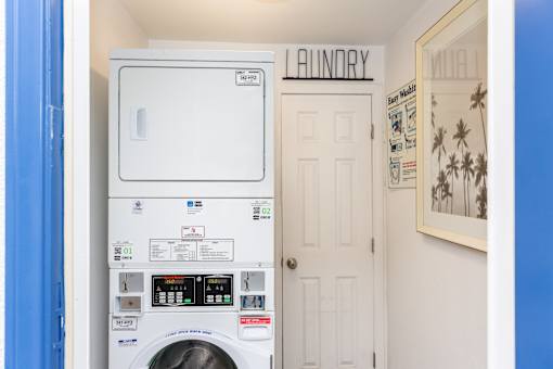 A washing machine in a laundry room with a door and a sign above it.
