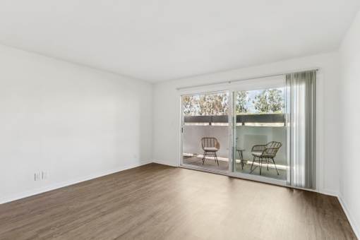 A room with a wooden floor and a sliding glass door.