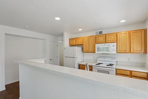 A kitchen with wooden cabinets and white appliances.