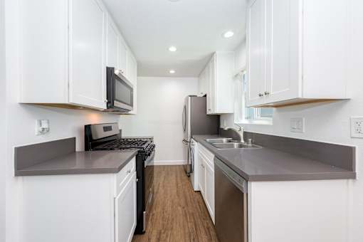 A modern kitchen with white cabinets and stainless steel appliances.