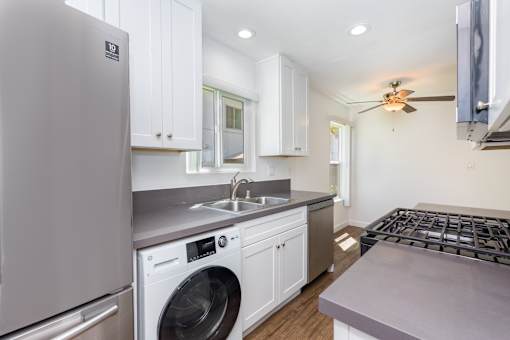A modern kitchen with a washing machine and a refrigerator.