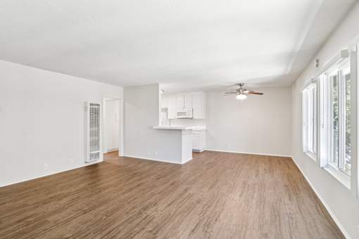A living room with wooden floors and a ceiling fan.