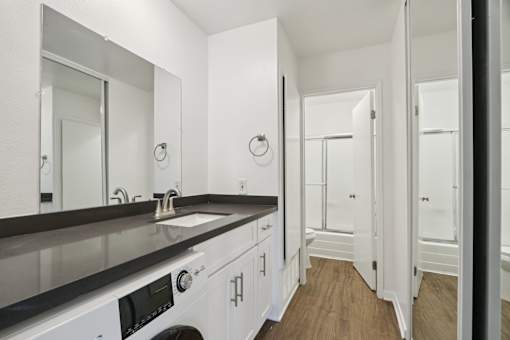 A view of the bathroom with washer in it