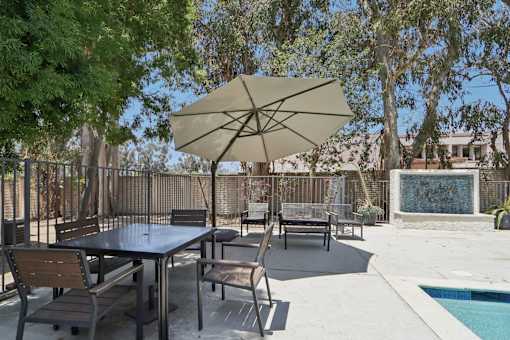 A patio with a table and chairs under an umbrella.