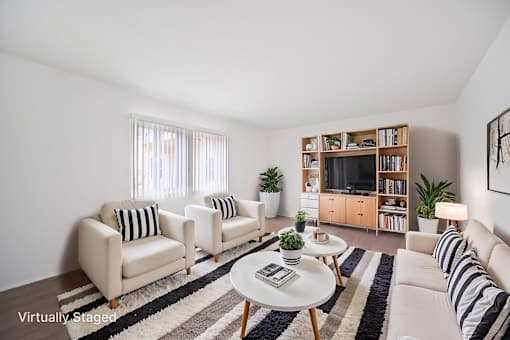 A living room with a white couch, a coffee table, and a bookshelf.
