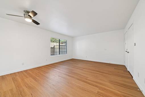 A room with wooden flooring and a ceiling fan.