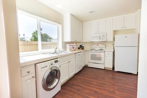 kitchen with white cabinets and white appliances, also washer/dryer combo