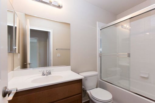 a bathroom with toilet, sink, and tub/shower
