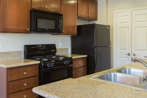 a kitchen with dark cabinets and black appliances