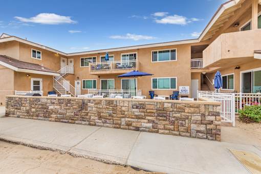 A sunny day at a sandy beachfront with apartment buildings.