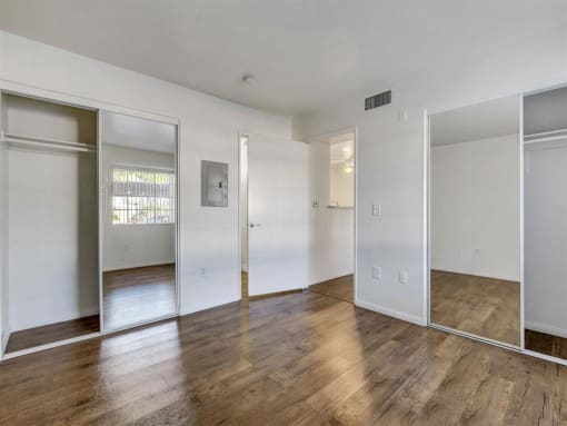 an empty room with white walls and wood floors