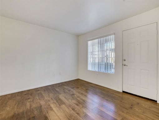 a bedroom with hardwood floors and white walls