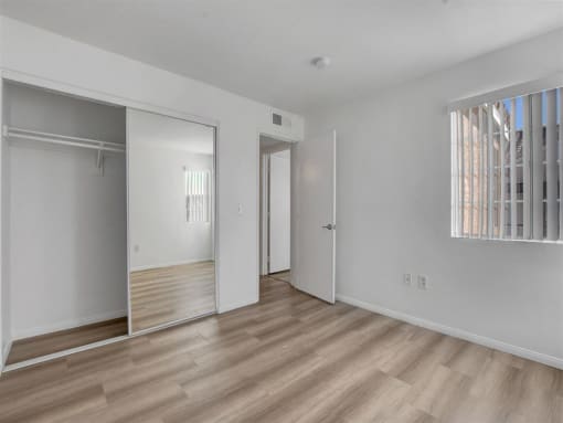 a bedroom with a door to a closet and a window