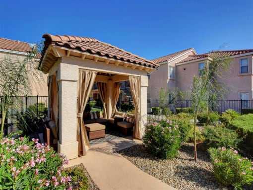 a gazebo with curtains in a garden