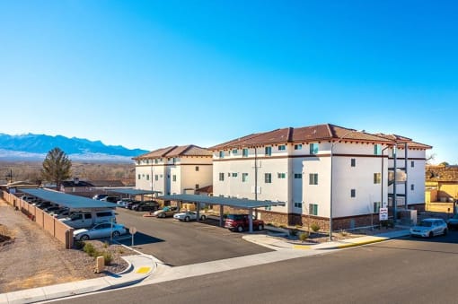 a building with a parking lot and mountains in the background