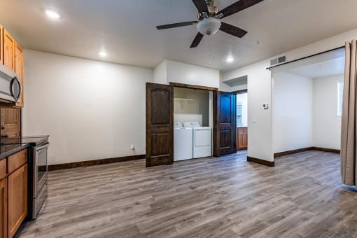 a kitchen and living room with a ceiling fan