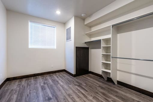an empty room with a closet and a window
