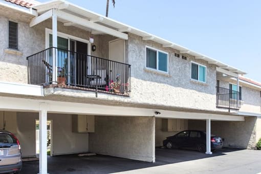 a white apartment building with a car parked in front of it