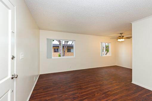 Living room with wood flooring and a ceiling fan.