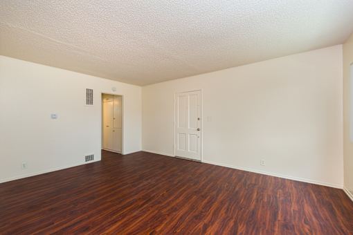 A living room with wooden floors and white walls.