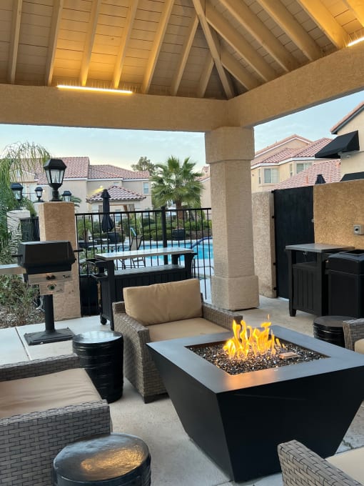 a patio with a fire pit and seating around it