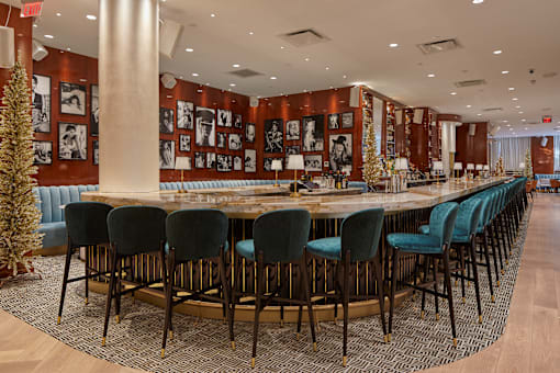 Upscale bar with marble counter and teal seating at Bay One Apartments, Bayonne