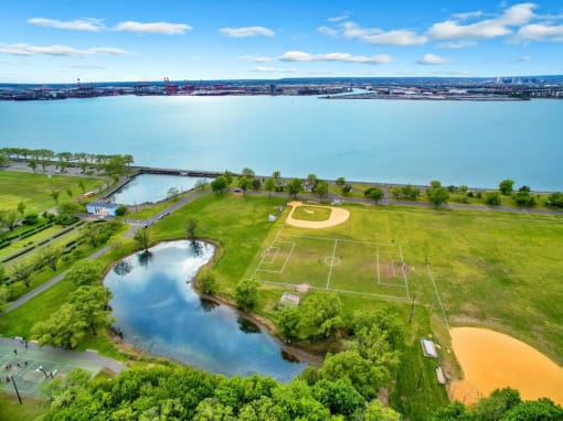 a park with a soccer field and a body of water in the background
