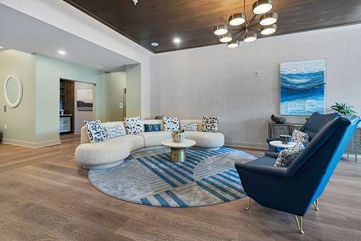 Resident lounge with curved sofa and modern furnishings at Aster Grove Apartments, New Jersey