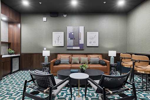 Resident lounge with leather sofa and modern furnishings at Aster Grove Apartments, Warren, 07059