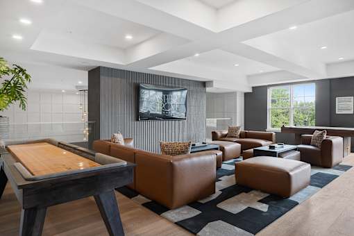 A modern living room with a pool table and leather furniture.