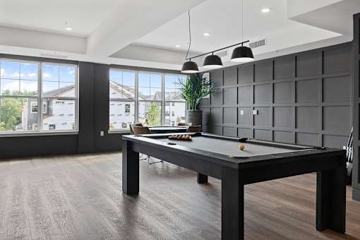 A pool table in a room with a view of the outside.