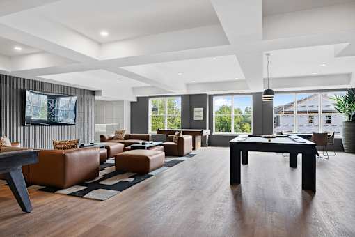 A modern living room with brown leather furniture and a flat screen TV mounted on the wall.