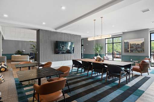 A modern dining room with a long table and chairs.