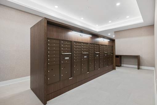 A row of brown mailboxes are lined up on a wall.