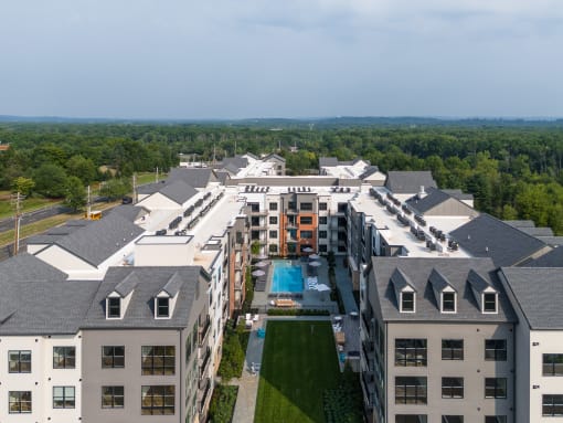 an aerial view of a large building with a pool and trees