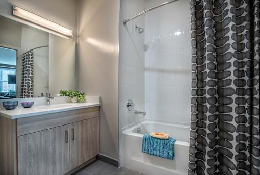 Bathroom with wood vanity and tub shower combo at Inwood at Renaissance Square Apartments, Marlton