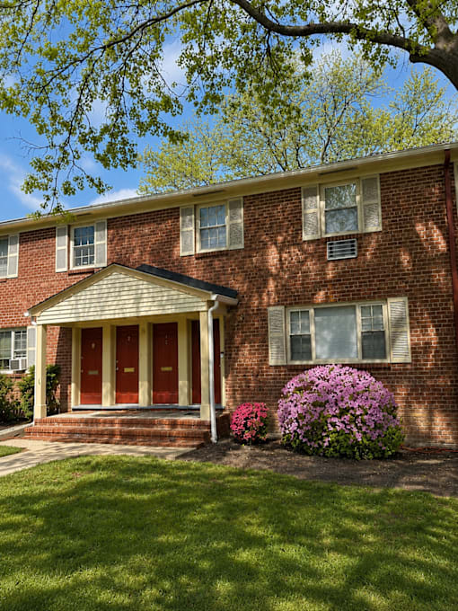A red brick house with a white front door and windows.