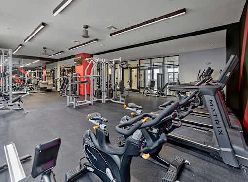 a gym with treadmills and other exercise equipment in a building with glass doors